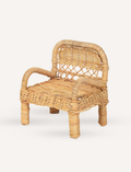 A Doll Chair - Rattan from Fabelab and a matching round wicker table are placed side by side against a plain background. The chair features a rounded backrest and armrests, while the table showcases a woven pattern on its sides. Ideal for an interior decorator seeking a nostalgic, retro look, both items are crafted from light-colored wicker.