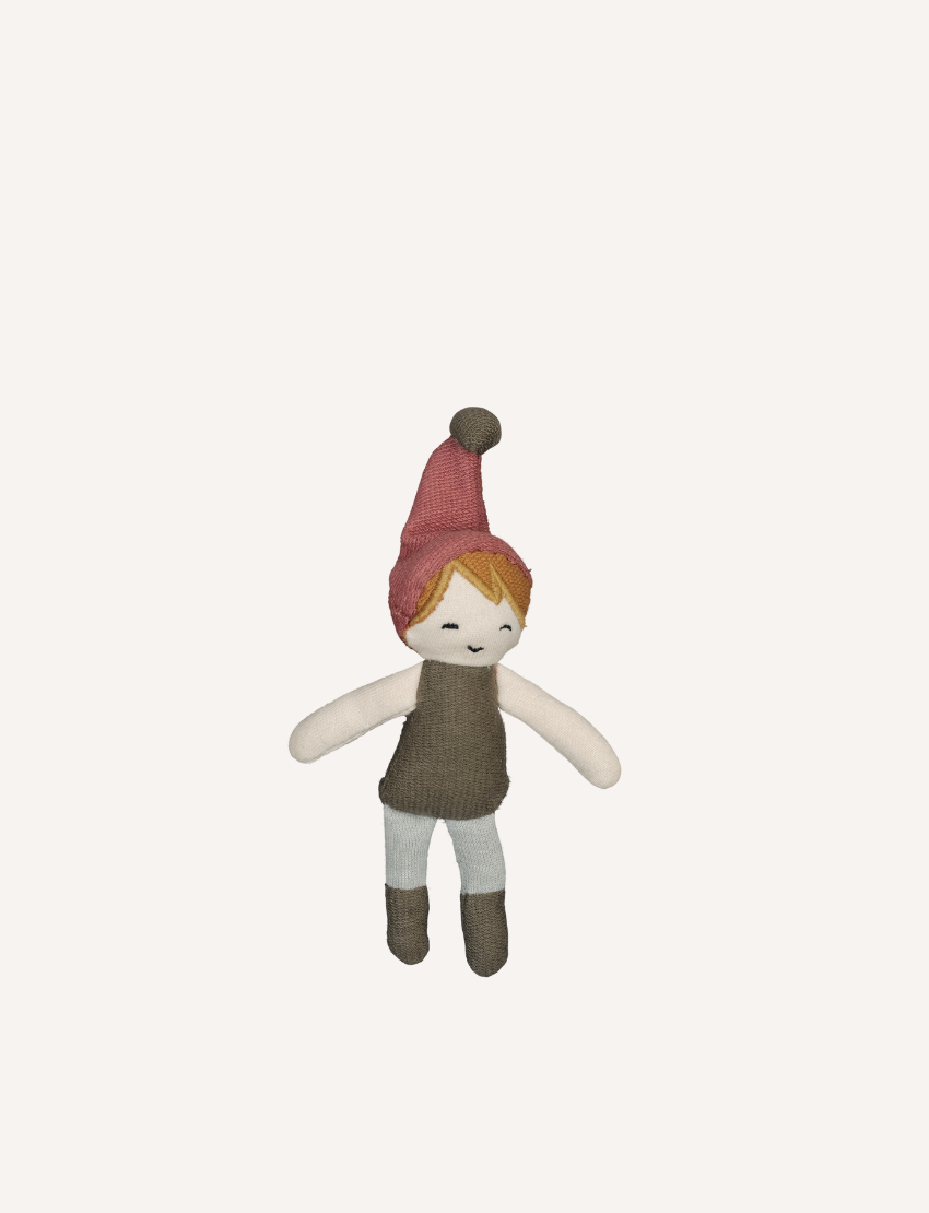 Introducing the Christmas Pocket Friend - Elf Boy by Fabelab: a charming soft doll with an orange-haired elf, wearing a pink hat, brown vest, and light-colored pants. With simple features and outstretched limbs, it's perfect for travel or companionship.