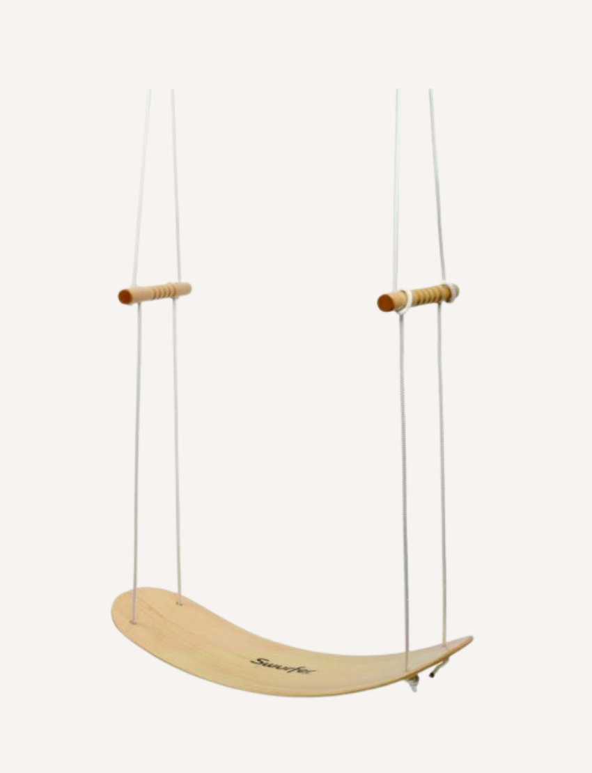 A Swurfer Swingboard by Flybar, featuring a wooden curved board with the brand name "Flybar" printed on it. It comes with two sturdy white ropes accented in orange and two wooden handles. The board includes four holes for rope attachment.