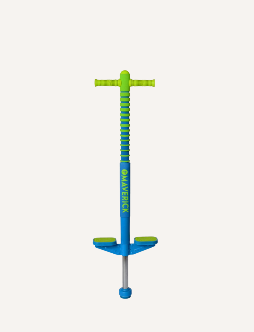 A blue Flybar Maverick Pogo Stick with green handle grips and non-slip foot pegs. The word "Maverick" is written in green on the vertical shaft of the foam-covered metal frame. The Maverick Pogo features a robust metal spring mechanism at the bottom for high-flying fun.