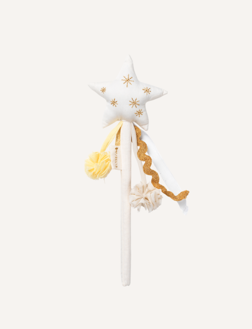 The Fabelab Fairy Wand is crafted from organic cotton with a star-shaped design and fabric handle. Adorned with gold star embroidery, it features two pom-poms and yellow/gold ribbon streamers, perfect for imaginative play against a plain white background.