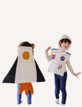 The Wings - Spaceship cape by Fabelab is a black fabric children’s cape with yellow straps on the front and a hood at the top. The bottom of the cape features orange fabric shaped like bursts or flames, giving it the appearance of a rocket launch.