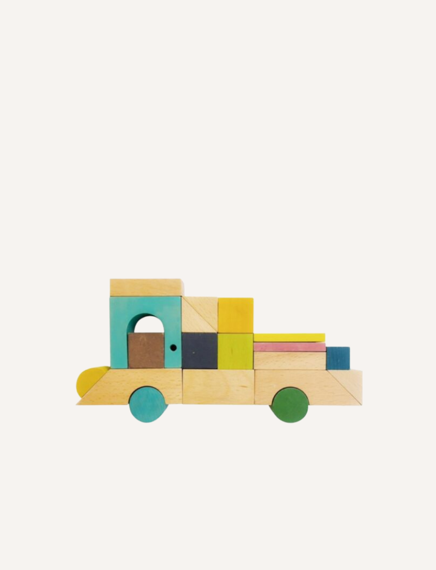 The Tsumiki House of Blocks by kiko+ and gg* features a delightful wooden toy house with a yellow roof. This charming house includes a small window with four panes, a rectangular door, and two strings—one ending in a small dog and the other in a tree. It comes as part of a 41-piece set.