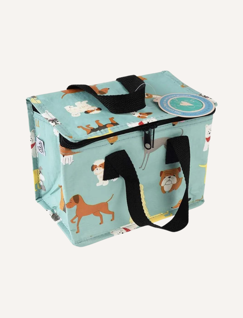 The Rex London Insulated Lunch Bag by Rex London showcases an open lid, revealing a reflective interior. It features a dark background adorned with vibrant rocket and spaceship illustrations, complemented by red zippers and handles.