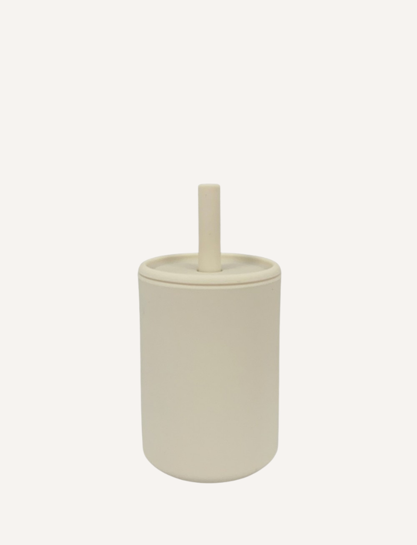 The Sippy Cup by Rommer Co is a light green, cylindrical container made of premium silicone, featuring a matching lid with a vertical handle on top. The smooth, matte material ensures it’s easy to clean. The product is showcased against a white background.