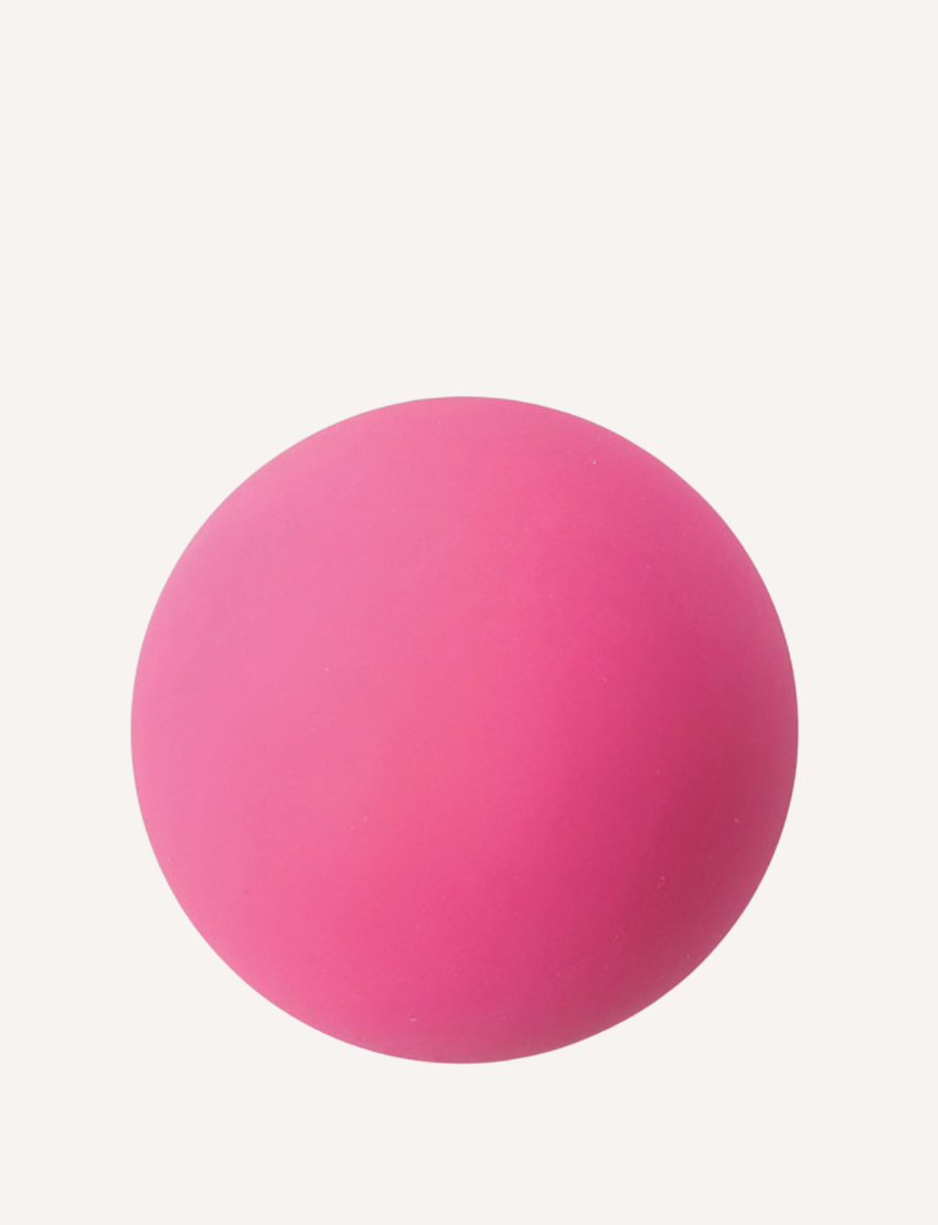 The Sensory Genius Sqwooze ball, a smooth, round, solid pink ball made of a soft material like rubber or silicone, is centered against a plain white background.