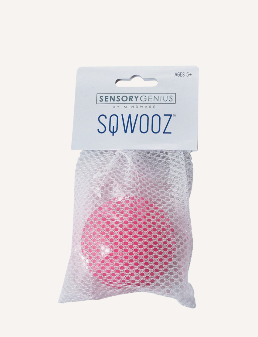 The Sensory Genius Sqwooze ball, a smooth, round, solid pink ball made of a soft material like rubber or silicone, is centered against a plain white background.