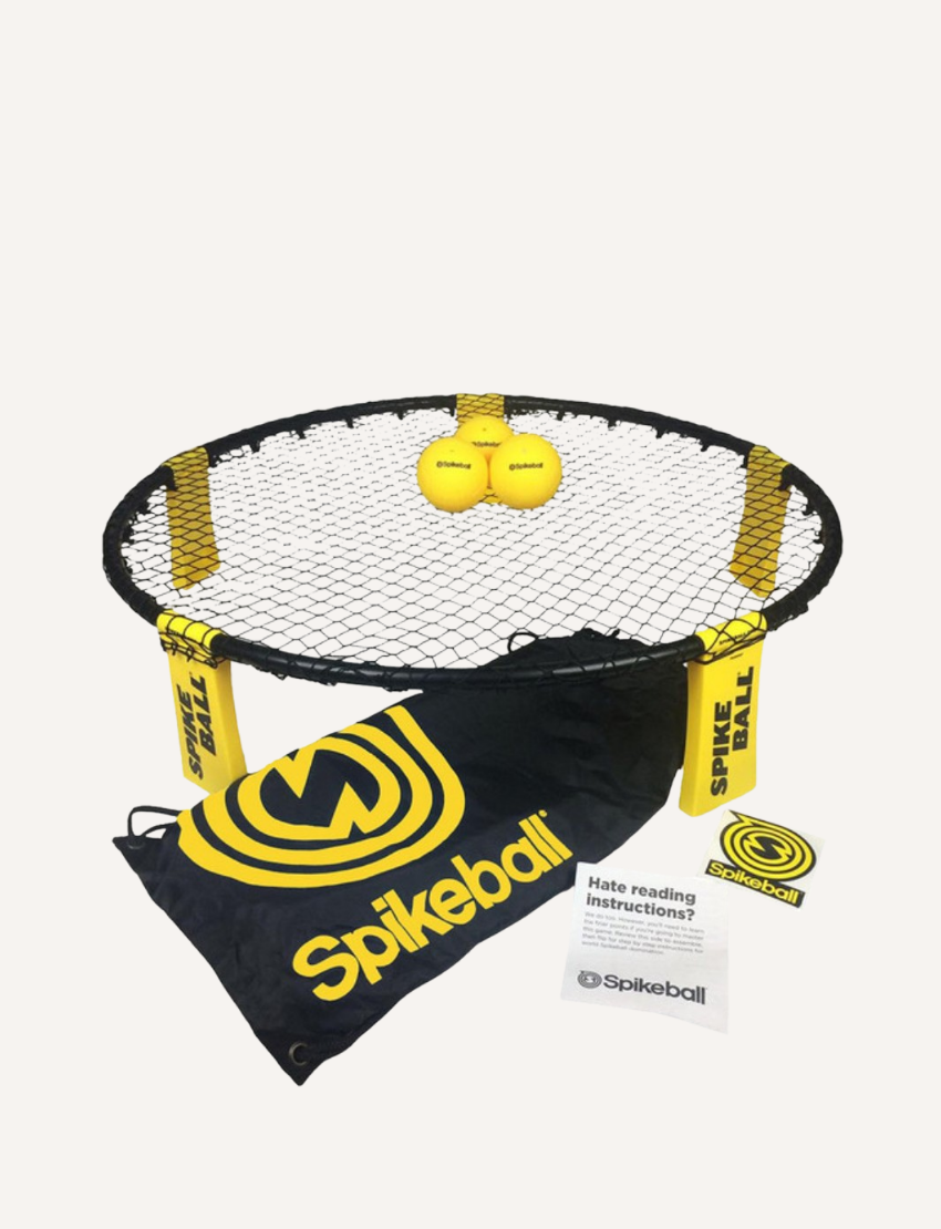 Image of the Spikeball Kit - Original by Spikeball, featuring a yellow and black drawstring bag with the Spikeball logo, two yellow balls also branded with the logo, a folded circular net frame, netting, a rulebook, and a Spikeball box in the background.