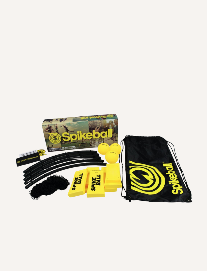 Image of the Spikeball Kit - Original by Spikeball, featuring a yellow and black drawstring bag with the Spikeball logo, two yellow balls also branded with the logo, a folded circular net frame, netting, a rulebook, and a Spikeball box in the background.