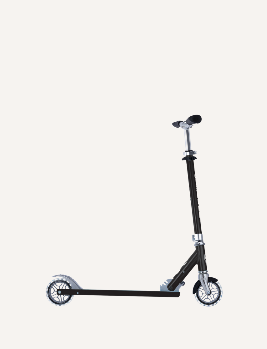 The Globber Flow Element Scooter with Lights is a black kick scooter featuring LED light-up wheels, a silver adjustable handlebar, and a foldable frame, all set against a plain white background.