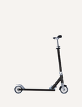 The Flow Element Scooter with Lights by Globber, featuring a sleek black and silver design, is shown. It has handlebars with black grips, a stand, and a rear brake. The scooter is positioned against a white background.