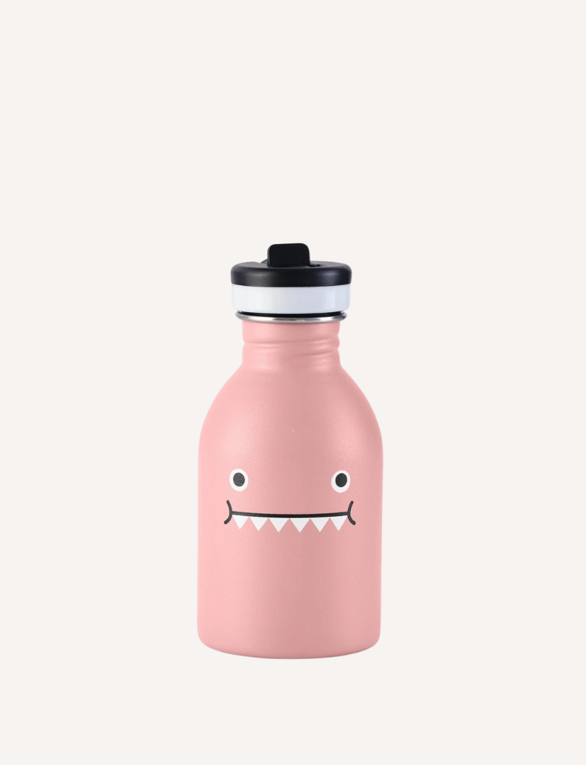 The Noodoll Stainless Steel Bottle features a green design with cartoonish circular eyes and a jagged mouth, complemented by a leak-proof black lid with silver trim, making it stand out on its simple white background.
