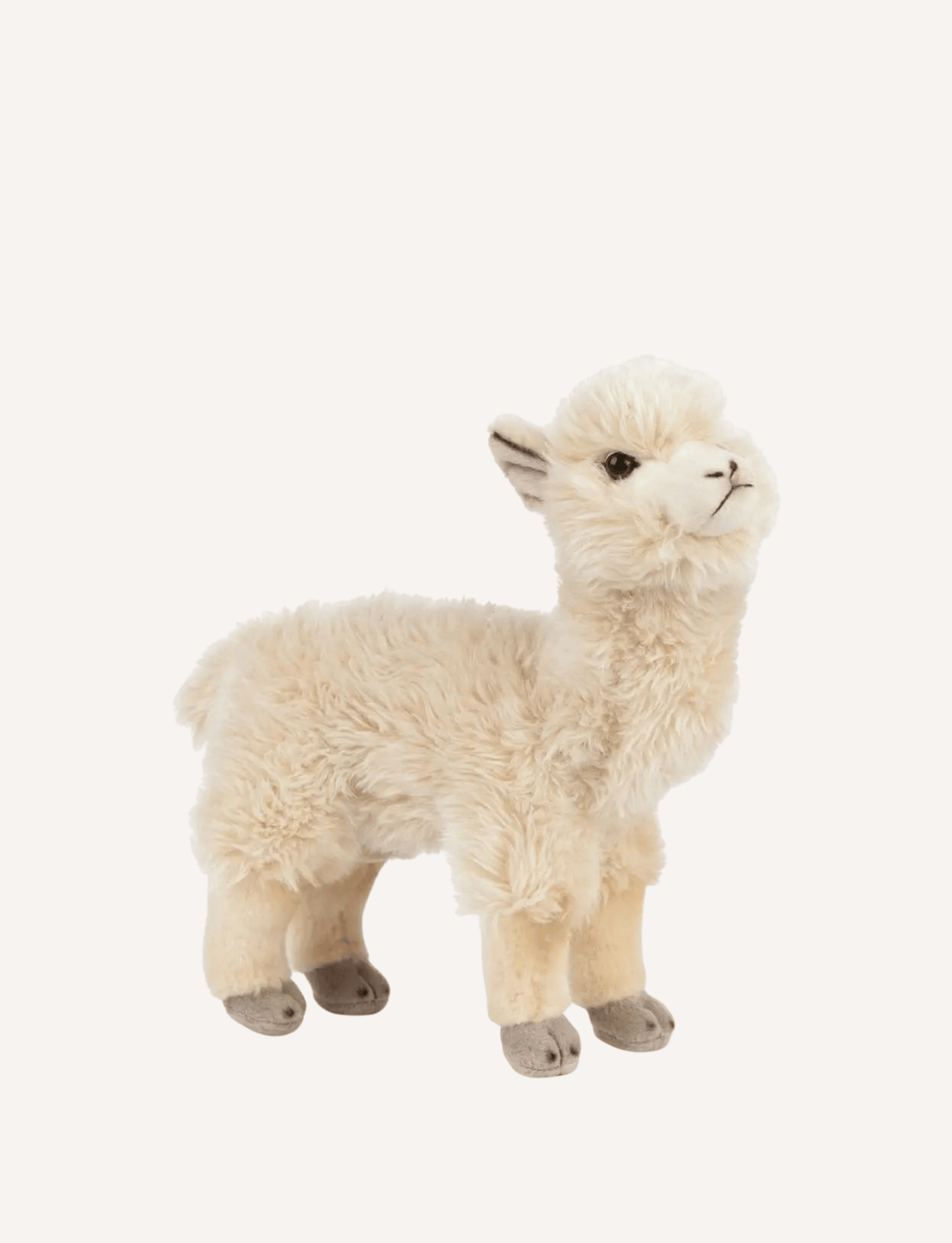 The Living Nature Alpaca by Living Nature is a non-toxic, plush soft toy featuring beige fur and a friendly alpaca standing on all four legs. It boasts detailed elements such as soft ears, small eyes, and a cheerful expression against a plain white background.