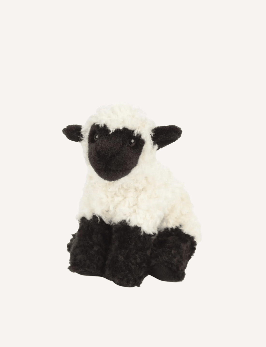 A small premium Living Nature Lamb soft toy, crafted by the brand Living Nature, is depicted against a plain white background. This charming lamb features a white body with a black face, ears, and legs. It is non-toxic and perfect for sharing educational animal facts with little ones.