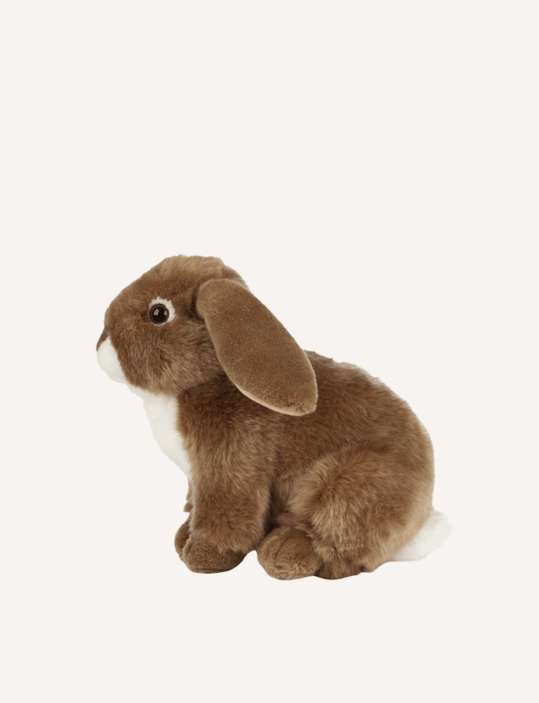 The Living Nature Brown Rabbit, a soft toy by Living Nature, is shown in a side profile on a plain white background. The toy features soft, brown fur, a white underbelly, dark eyes, and long floppy ears. It is made from recycled plastics to promote sustainability.