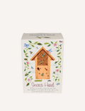 An Insect Hotel - Wonders of Nature by Rex London, crafted from wood with a slanted roof and multiple small holes, is placed in front of its packaging box. The box showcases colorful illustrations of flowers and insects, prominently features the text 