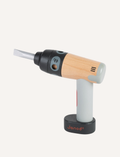 The BricoKids DIY Drill from Janod features a wooden handle and a grey plastic body. It comes with a gold toy drill bit and a silver toy screwdriver bit, both placed next to the drill. The brand name 