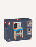 The image depicts a box containing the BricoKids DIY Giant Magnetic Workbench by Janod, designed for children aged 3 to 8. The packaging includes illustrations of the assembled workbench complete with tools, a chalkboard, and storage options, along with the brand logo and age recommendation clearly visible.