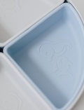 The Baby By Beach Multi-use Silicone Divider Plate is a round baby feeding plate with a lid, crafted from food-safe silicone and divided into four triangular sections. This multifunctional design features two light blue and two dark blue sections with simple embossed sea creature designs on the lid and sections.