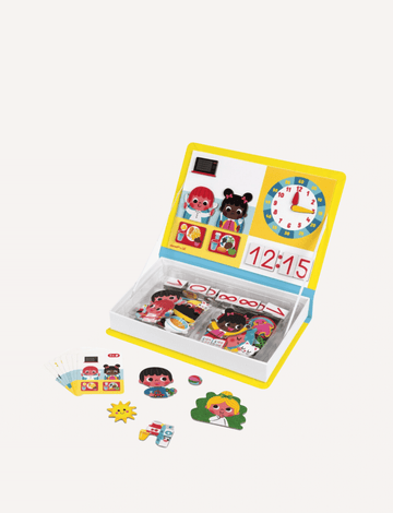 The "Learn Time Magnetic Book" by Janod is a children's educational toy set that includes a vibrant board with cartoon characters, a clock showing 12:15, and various magnetic pieces for storytelling and activity cards. The magnetic book is propped open, displaying all the pieces neatly within the storage area to help kids learn to tell the time.