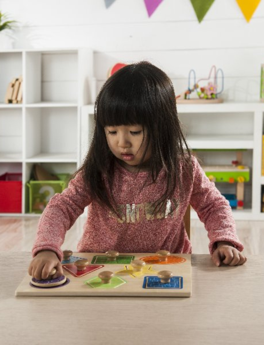 The Shape Knob Puzzle by Ever Earth is a wooden board featuring an assortment of vibrantly colored shapes, such as a blue square, green hexagon, red circle, yellow star, orange oval, green triangle, and purple pentagon. Each shape includes a knob for easy handling.