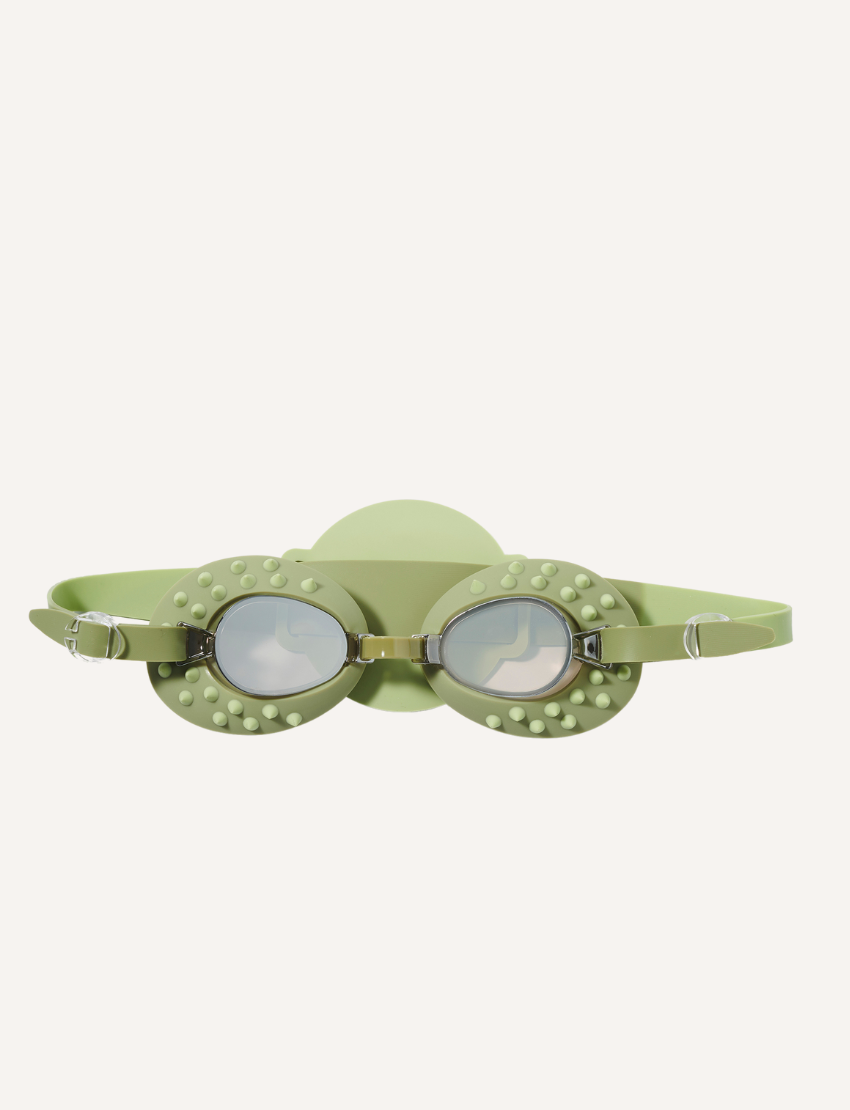 The Kids Swim Goggles by Sunnylife feature a playful swan-shaped head strap, with purple frames and reflective lenses. The head strap showcases a white body and yellow accents, complete with a crown. Both items are displayed against a plain white background.