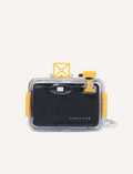 A Sunnylife Underwater Camera, encased in a transparent protective shell with yellow accents, rests on a textured stone surface. The camera boasts a focus-free 28mm lens and features a striped design in white, orange, and yellow.