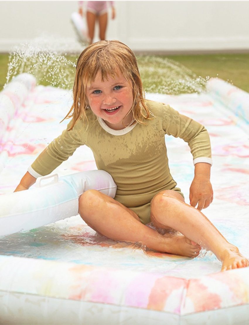 Image of the Sunnylife Slip, Slide and Body Board Set - Tie Dye Multi, showcasing a light pastel tie-dye pattern featuring swirls of pink, blue, and yellow. Two small inflatable pool rings with matching patterns are positioned next to the slide against a plain white background.