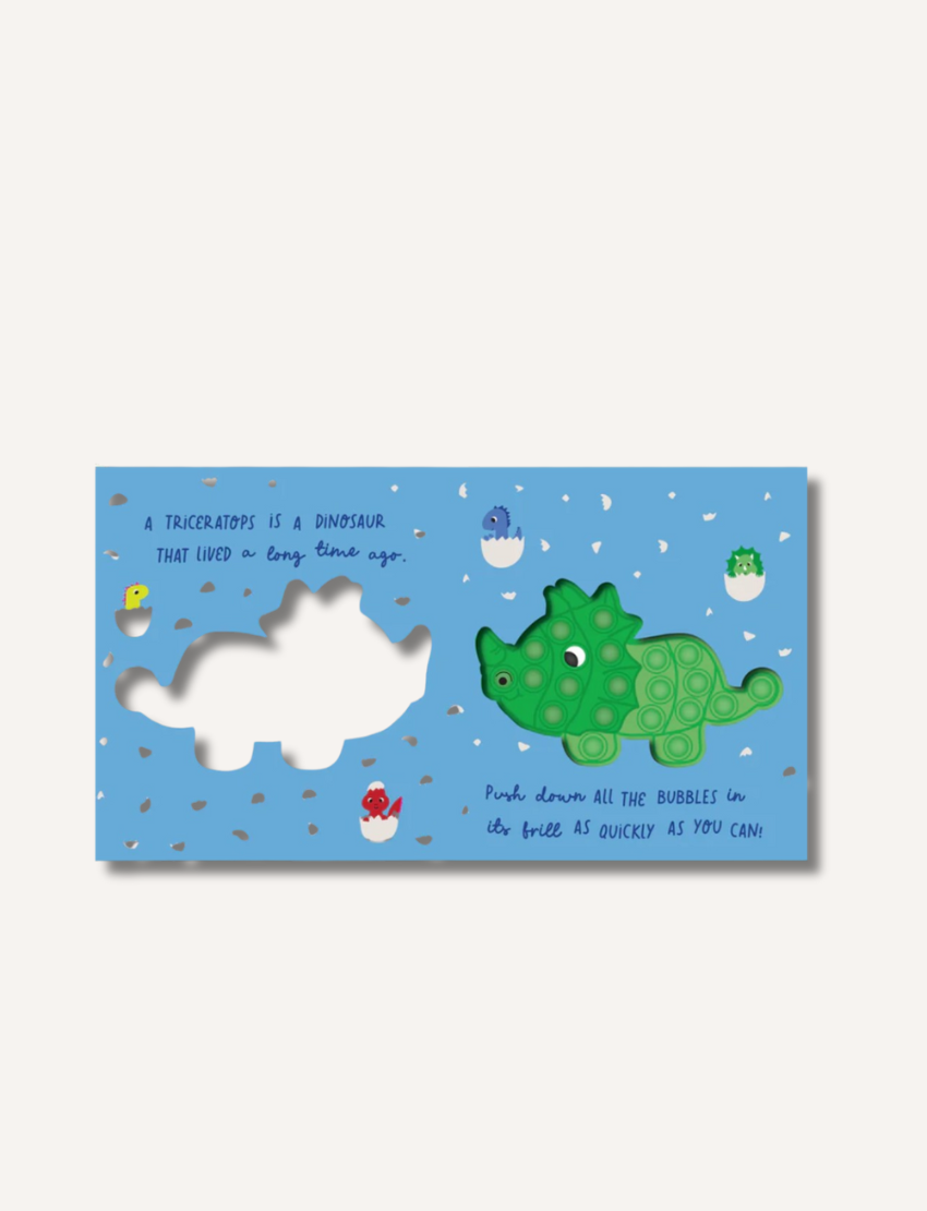 The "Dinosaur Bubble Pops Book" by Lake Press is a children's dinosaur book featuring a blue cover with an attached green dinosaur-shaped pop-it toy, providing visual, tactile, and auditory play. The cover also includes illustrations of other colorful dinosaurs framing the border.