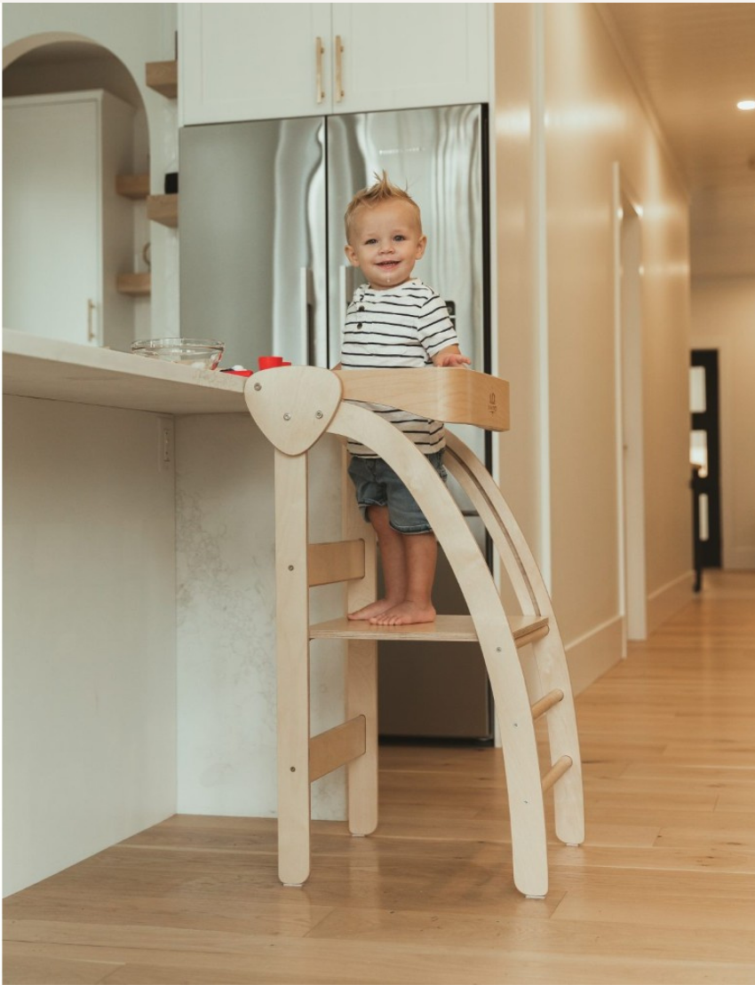 The Pikler Observation Tower by Artiwood is displayed in a folded position. This wooden climbing arch features a natural finish, curved sides, and multiple horizontal rungs for climbing. The sturdy structure makes it ideal for children's play.