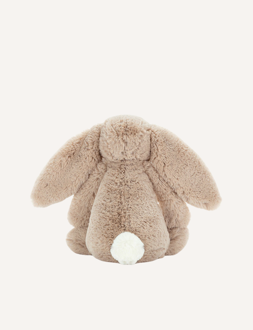 Introducing the Bashful Bunny by Jellycat, a charming plush toy shaped like a beige rabbit with long, floppy ears. This endearing bunny features a pink nose and inner ears, along with a content expression on its face. Made with Jellycat's signature soft fur, Bashful Bunny is posed sitting upright against a plain white background—making it the perfect gift!