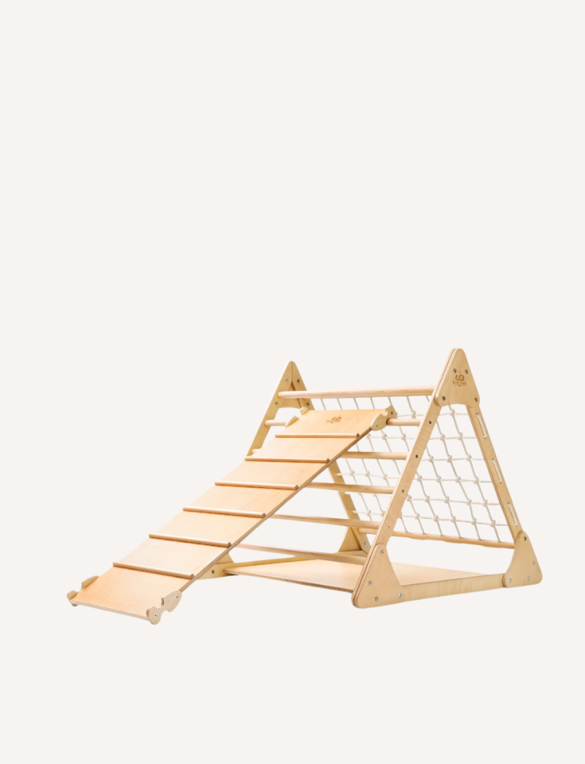 The Artiwood Pikler Slide and Climber Set is a wooden climbing structure for children featuring an A-frame design. One side has horizontal climbing steps, while the other side incorporates a net for climbing. The wood is lightly finished to accentuate its natural grain.