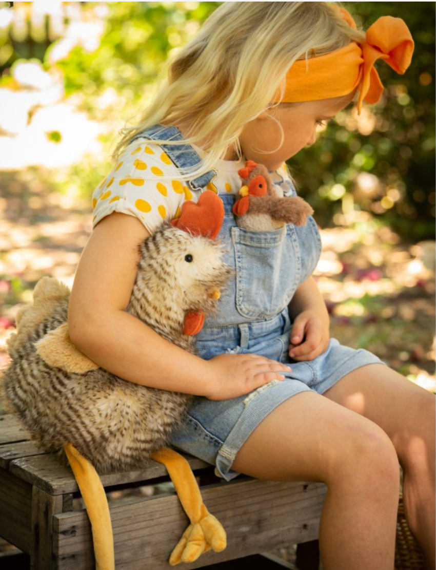 Introducing Rupert The Rooster by Nana Hutchy: a plush toy resembling a sitting rooster, featuring brown and white striped feathers, a red comb, and yellow beak and feet. The toy's legs are extended forward.