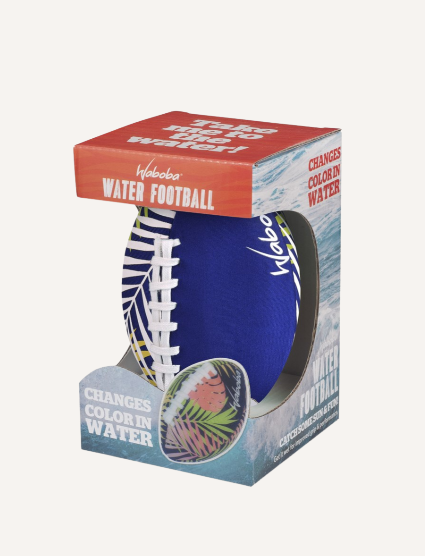 The packaging for the Waboba 6" Colour Changing Water Football displays a blue football with white laces. The box emphasizes its ability to change color when submerged in water, set against a backdrop of water and splash graphics.