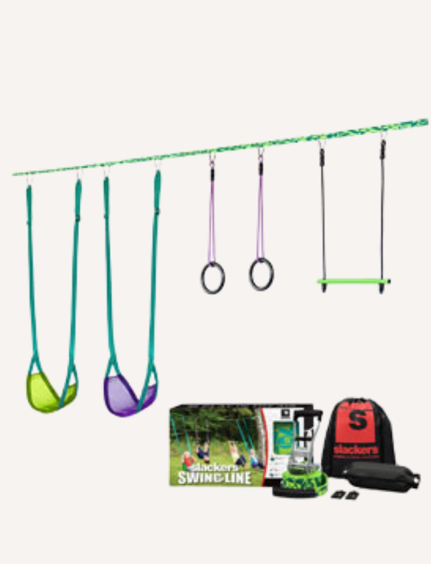 Introducing the Slackers Swingline: a versatile setup featuring two swings in vibrant green and purple, rings, and a trapeze bar, all connected to a slackline. The set comes complete with a sturdy box, an instruction manual for easy assembly, and a convenient backpack for effortless storage.