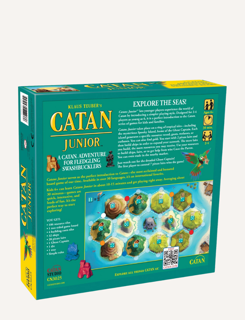 The image shows the back of a Settlers of Catan Junior board game box by VR Distribution, with a game description, components list, and a visual of the game board. The design is mainly green with pirate-themed illustrations.