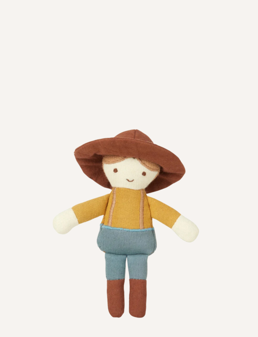 Introducing Pocket Friend - Farmer Joe by Fabelab: a charming fabric doll donning a brown hat, yellow shirt, blue overalls, and brown shoes. This delightful character features simple facial details with two eyes and a smiling mouth. Photographed against a plain white background.