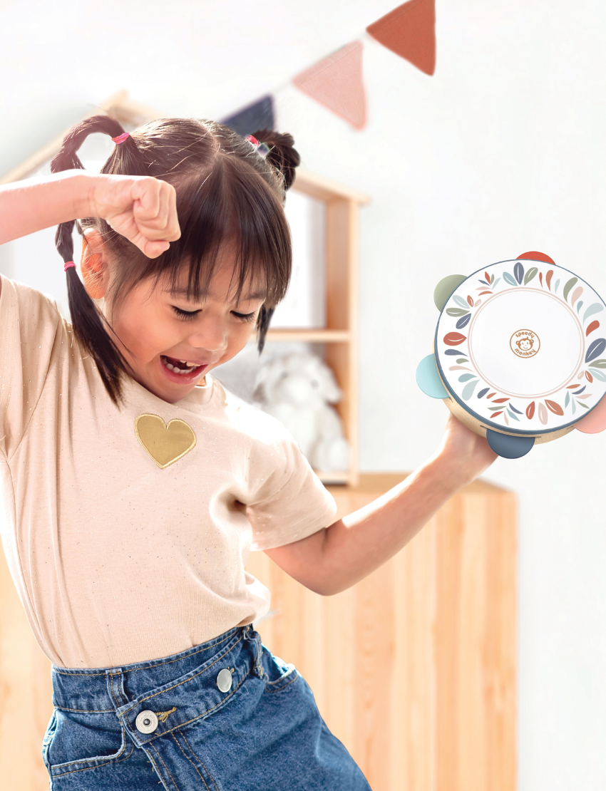 A Speedy Monkey tambourine crafted from wood, featuring vibrant metal jingles and a decorative top adorned with leaf designs in soft pastel shades, set against a plain white background.