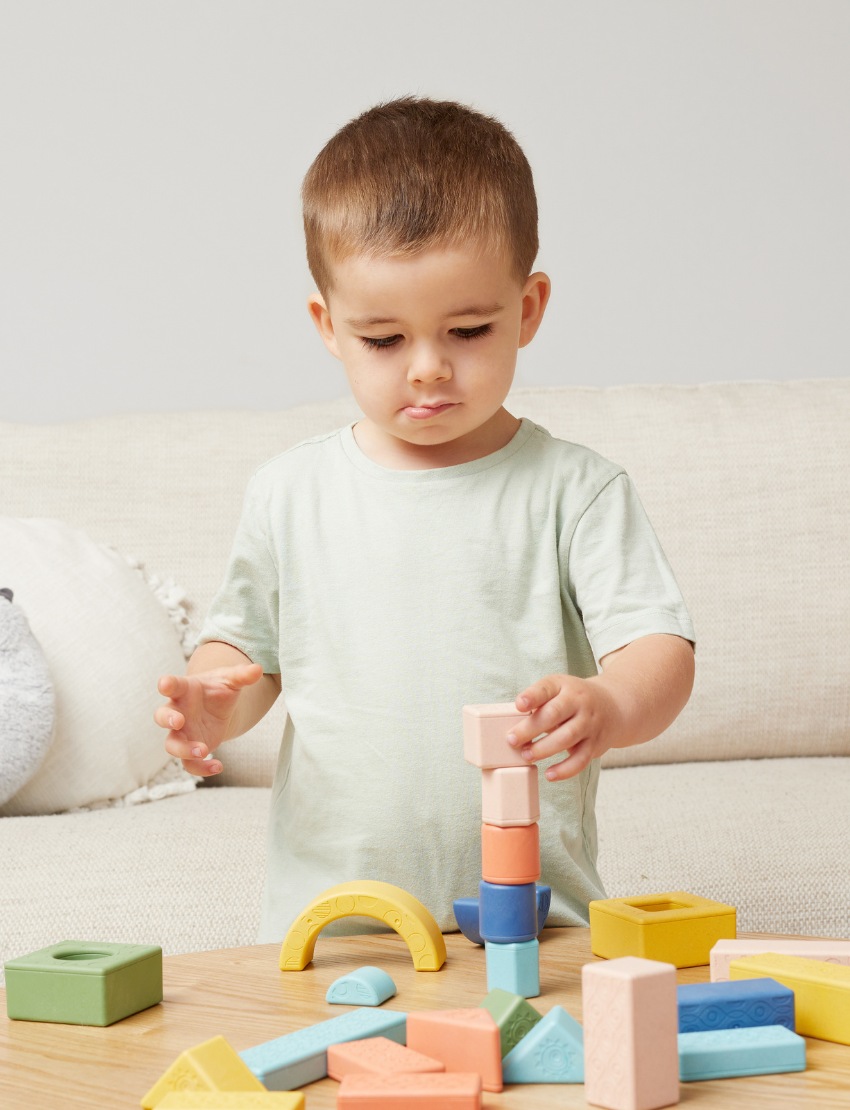 The "Rattle & Stack Blocks - Deluxe Pack of 24" from Tiger Tribe includes a vibrant collection of blocks in different shapes and sizes. The packaging is eco-friendly, designed for children aged 1-4, and features a convenient handle for easy transportation.