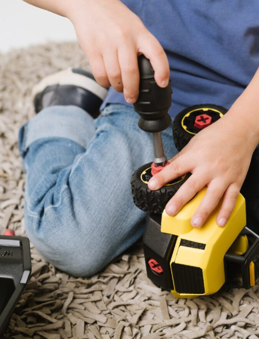 A Stanley Jr. Take Apart Construction Vehicles dump truck toy in yellow and black comes in a yellow box. The 23-piece set is ideal for young builders aged 3 and up.