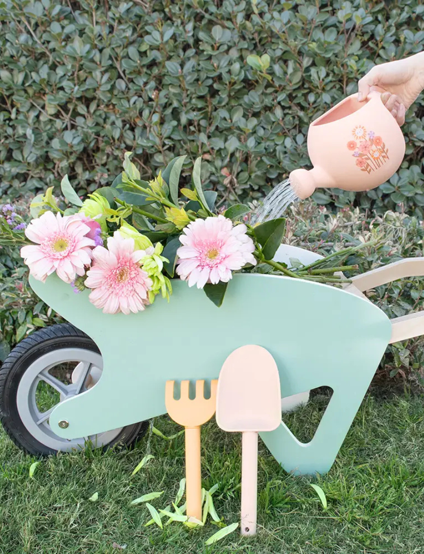 The Playground "My First Gardening Set" includes a blue silicone watering can with a yellow tractor, a green recycled rake, and a yellow spade for an ideal gardening experience.