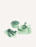 The Silicone Kitchen Playset by Playground features a selection of pastel green toy kitchen utensils, including a saucepan, a pot with a lid, a spatula, and a ladle—all arranged on a matching silicone mat. The items are showcased neatly against a simple backdrop.