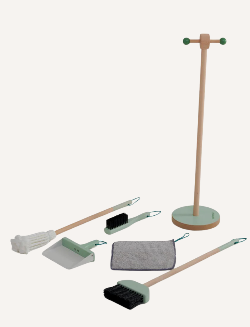 Introducing the Essentials Cleaning Set - Green by Moover, featuring a light wooden stand and a comprehensive set including a mop with white bristles, a brush with black bristles, a dustpan, a gray cloth, and a holder accented in green.