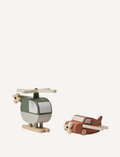 The Flexa Wooden Helicopter and Plane set features a green and white helicopter with wooden propeller and skids, alongside a brown airplane equipped with a wooden propeller and wheels. Both toys boast a minimalist design.