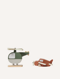 The Flexa Wooden Helicopter and Plane set features a green and white helicopter with wooden propeller and skids, alongside a brown airplane equipped with a wooden propeller and wheels. Both toys boast a minimalist design.