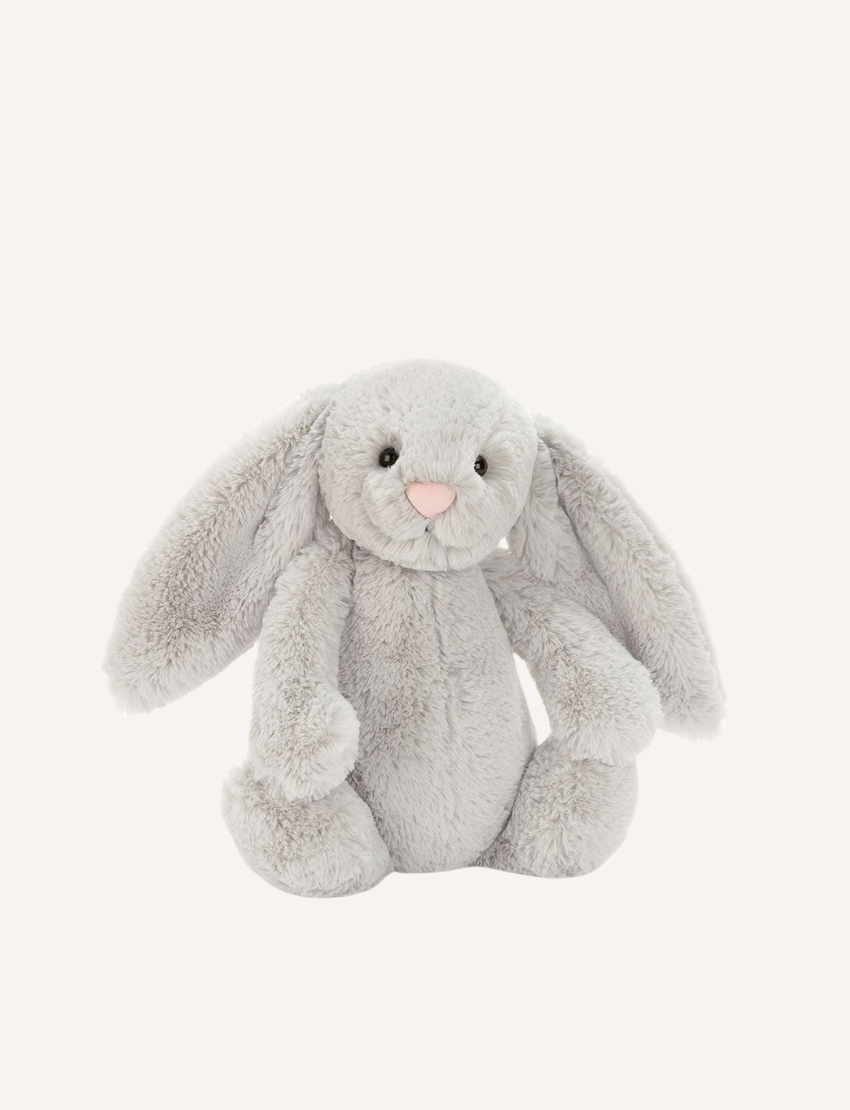 Introducing the Bashful Bunny by Jellycat, a charming plush toy shaped like a beige rabbit with long, floppy ears. This endearing bunny features a pink nose and inner ears, along with a content expression on its face. Made with Jellycat's signature soft fur, Bashful Bunny is posed sitting upright against a plain white background—making it the perfect gift!