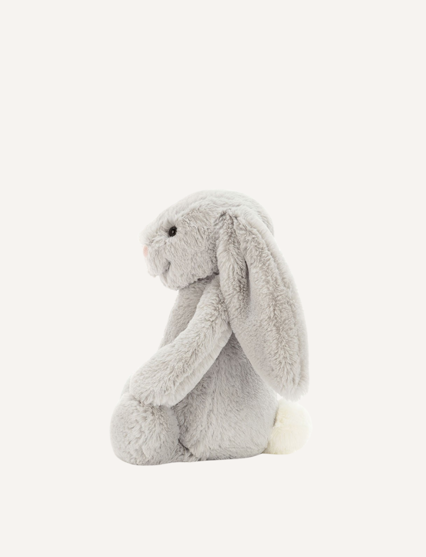 Introducing the Bashful Bunny by Jellycat, a charming plush toy shaped like a beige rabbit with long, floppy ears. This endearing bunny features a pink nose and inner ears, along with a content expression on its face. Made with Jellycat's signature soft fur, Bashful Bunny is posed sitting upright against a plain white background—making it the perfect gift!