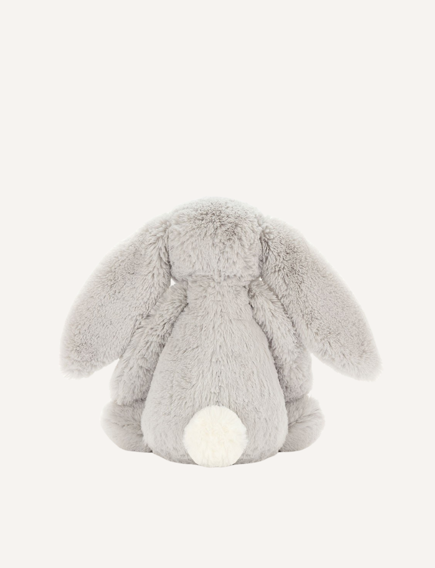 Introducing the Bashful Bunny by Jellycat, a charming plush toy shaped like a beige rabbit with long, floppy ears. This endearing bunny features a pink nose and inner ears, along with a content expression on its face. Made with Jellycat's signature soft fur, Bashful Bunny is posed sitting upright against a plain white background—making it the perfect gift!