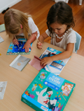 The Therapy At Home Fine Motor Intermediate Program is an open teal box with abstract designs featuring craft and activity sets to strengthen fine motor skills using reusable stickers, sand art, air-dry clay, glue, and storybooks.