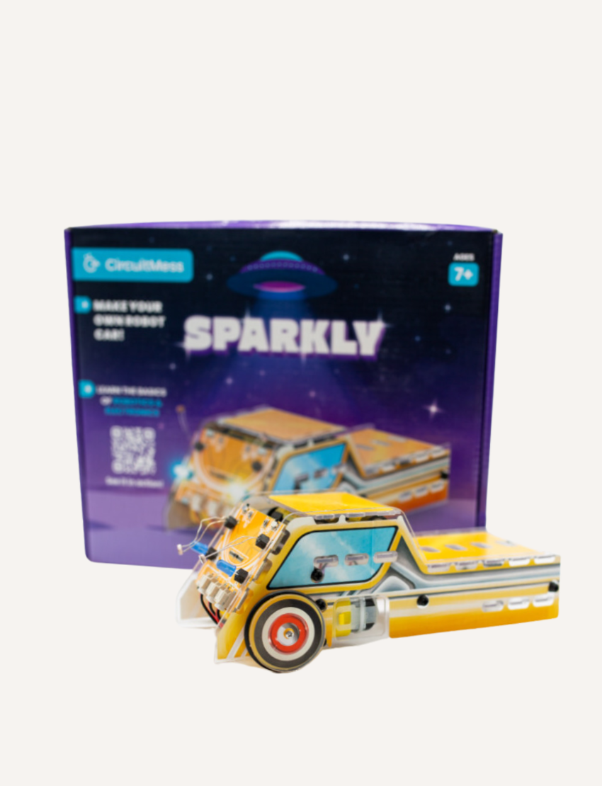 A toy robot car kit called "STEM Adventure - Sparkly Robot Car" by CircuitMess is displayed. The assembled car, in yellow and blue, sits in front of its packaging box, which features a car illustration and notes it is suitable for ages 7 and up.